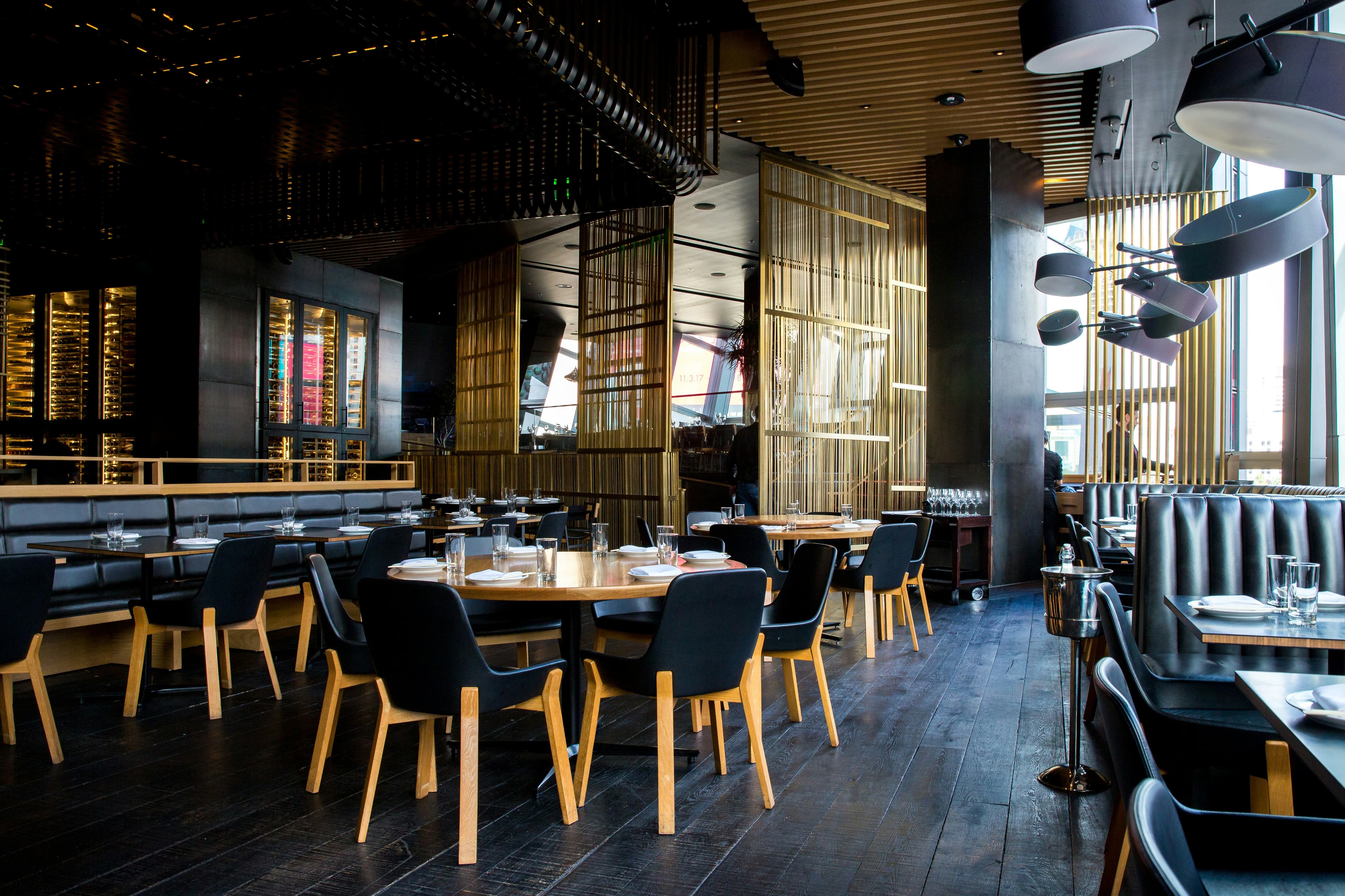 Restaurante con mobiliario de madera oscura, bancas y mesas a la medida